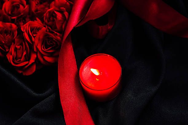istock Red roses and candle are arranged on a black fabric background for a romantic setting 2254966296