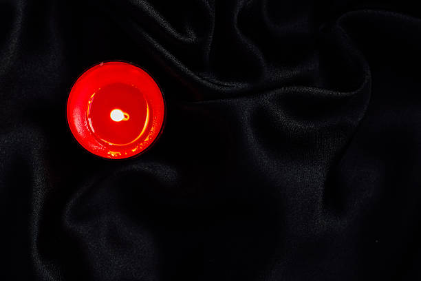 istock Red candle on dark fabric during night time for relaxation and ambiance setting 2254966332