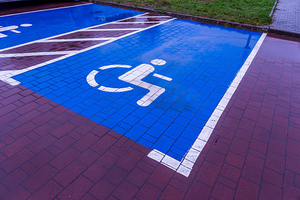 istock A parking space designated for individuals with disabilities is visible on a wet surface with rainwater pooling. The symbol is clearly marked in blue, indicating accessibility 2254966766