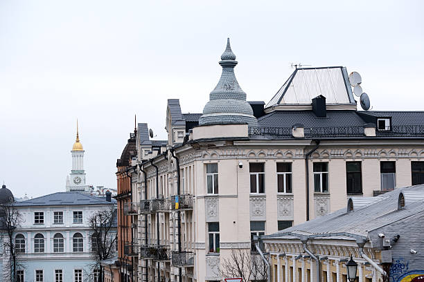 Historic buildings with ornate details rise against a cloudy sky, creating charm. Andreevsky Uzviz, Kyiv, Ukraine. December 8, 2025.