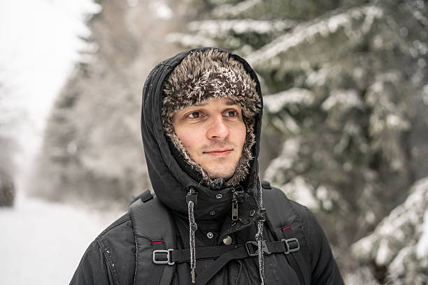 istock Winter Adventure: Man in Black Parka Walking Outdoors in Snowy Forest Setting 2254969231