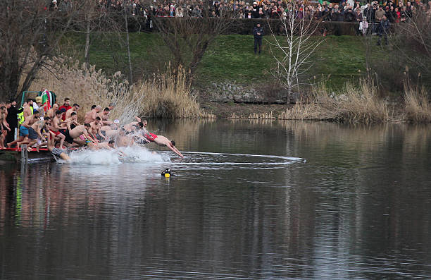 Sofia, Bulgaria - January 06, 2026: Many young men jump into the cold waters of the lake in Sofia's Druzhba district to save the holy cross thrown by the priest. This is an annual tradition to celebrate Epiphany in Bulgaria.