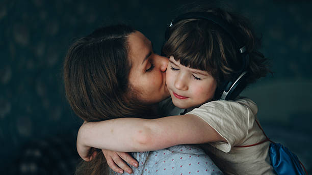 istock Mother kissing son - close embrace 2254974242
