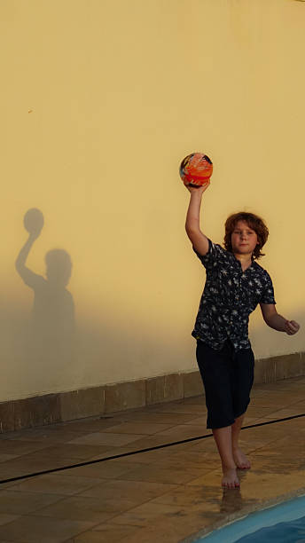 Caucasian young handball player in action and motion in mixed lights over black studio background. Fit male professional sportsman. Concept of sport, movement, energy, dynamic, healthy lifestyle.