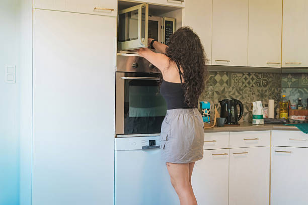 istock Middle-aged woman in her kitchen baking, she is opening the oven 2254975848