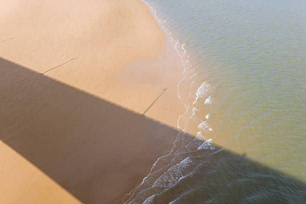 istock Shadow and gentle waves on sandy Atlantic beach 2254977693