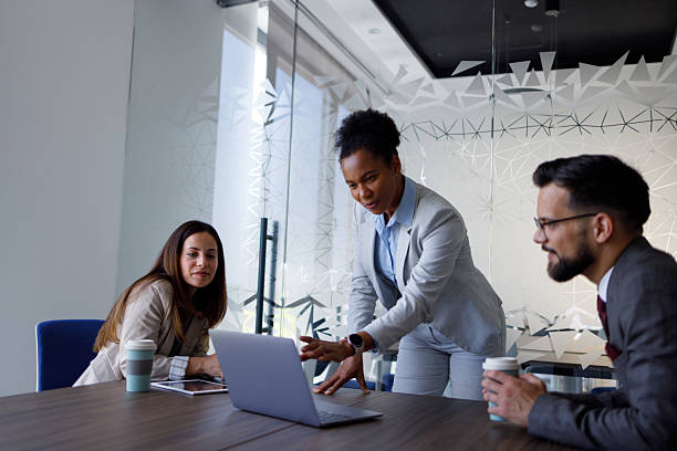 istock Diverse business professionals collaborating in a modern conference room, discussing project details and strategy using a laptop 2254978022