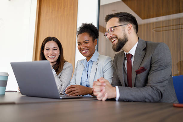 istock Diverse business professionals smiling, collaborating on a laptop during an office meeting 2254979007