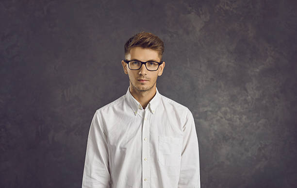 istock Studio portrait of serious young businessman or programmer standing on gray background. 2254984338