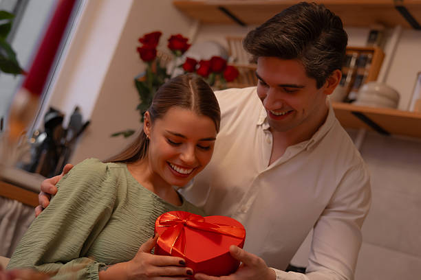 istock Happy couple holding heart shaped gift box together. 2254984865
