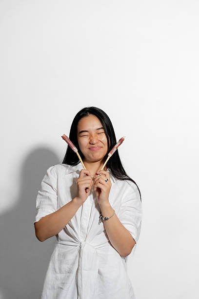 Emotional Asian woman wearing white, with tasty appetizers in hands