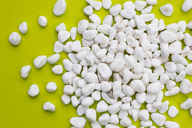 istock Smooth, white, polished pebbles scattered on a green surface. 2254990631