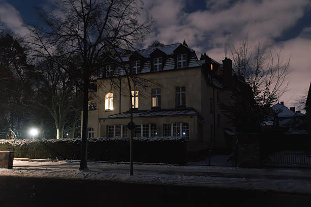 Berlin, Germany – January 6, 2026: Apartment building photographed at night with only a few illuminated windows during a widespread power outage. The surrounding residential area appears dark and quiet. Steglitz-Zehlendorf district