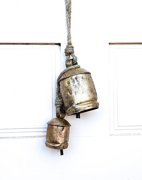 istock Santa Fe Style: Two Rustic Gold Christmas Bells on White Door 2254996734