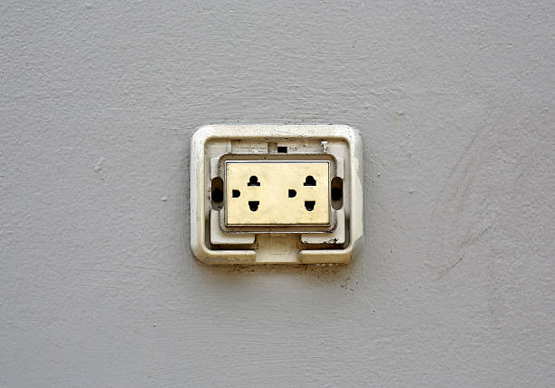A clean, white child proof multiple electrical outlet embedded in a plain white wall, with one plug connected on the right, highlighting functionality and modern interior design
