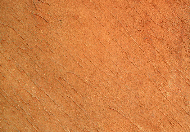 An artisan carefully hand-texturing a warm terracotta clay wall to create a rustic Mediterranean feel.