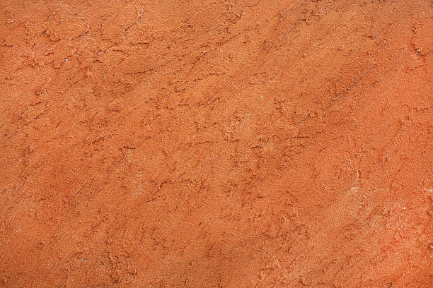 istock A craftsman applying a vibrant orange Venetian plaster to a modern interior wall. 2255010314