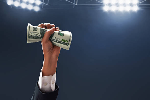 istock Businessman hand holding money on dark background 2255010390