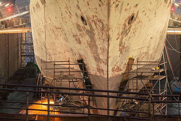 kandla anchorage, gujarat, india, on board ship - november 22, 2024 : crew members painting cargo hold using fallen chair hanging from hold inspection platform