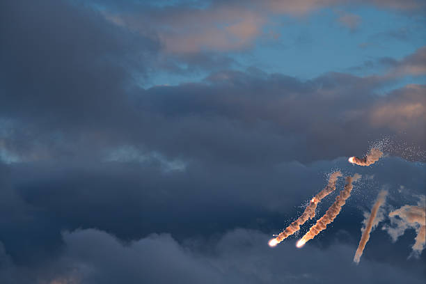 The silhouette of an aircraft flying overhead at sunset, with elevated highways and road signs on the ground.