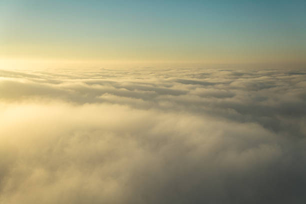 Aerial shot from above low clouds at sunrise.