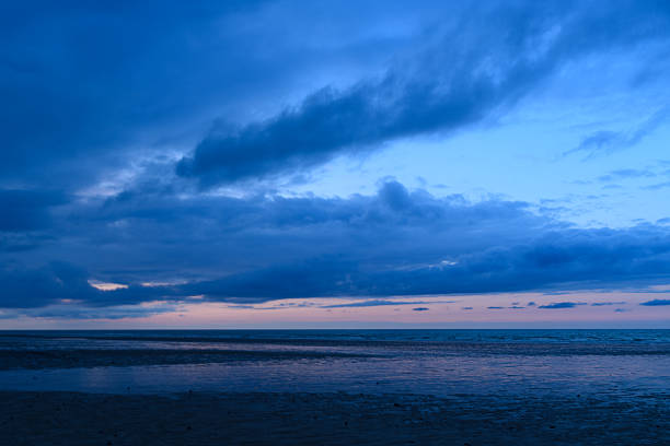 Cloudscape and seascape at ocean sunset with sandy beach in Portugal