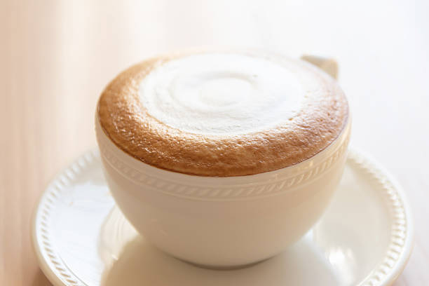 Creamy cappuccino foam cup saucer coffee latte art hot beverage white ceramic breakfast morning closeup