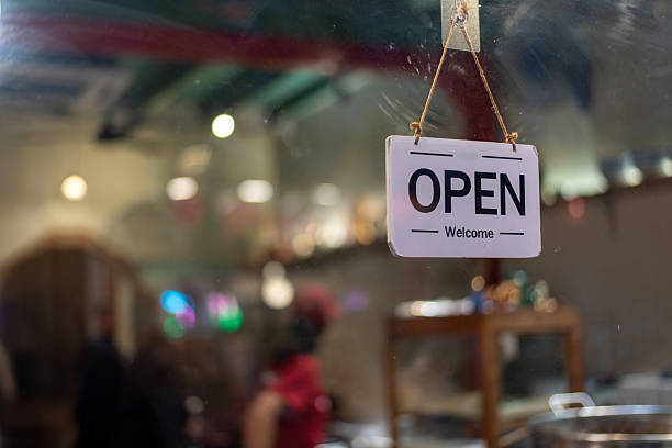 istock Open Sign Hanging on Glass Window with Blurred Shop Background 2255019305