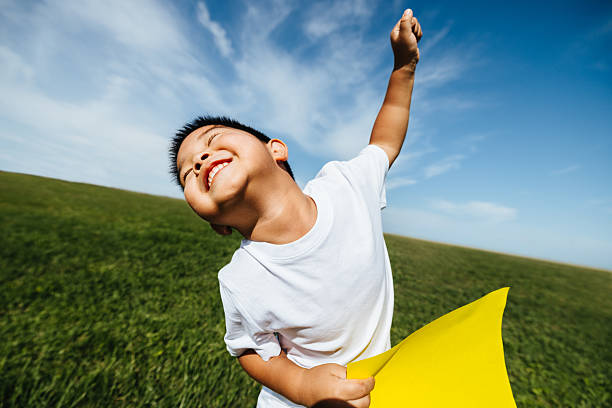 A joyful child runs through a wide grassy field on a sunny day, smiling and expressing carefree summer energy and playful outdoor freedom.