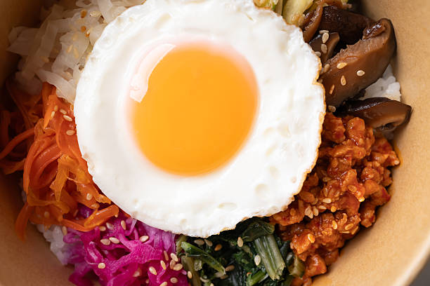 Bibimbap, Korean food, Cooked rice with vegetables, pork and egg in biodegrable bowl