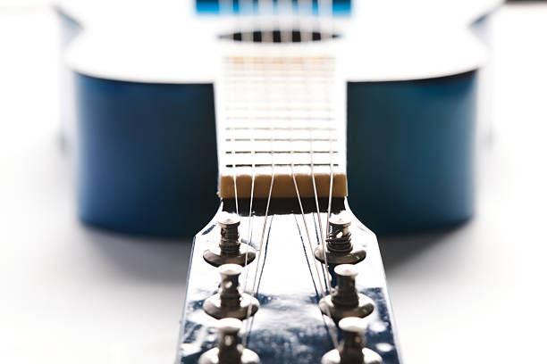 Blue acoustic guitar is illuminated by white daylight, close up