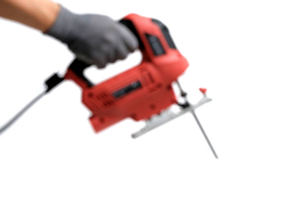 Blurred image of an electric jigsaw in his hand, highlighted on white background