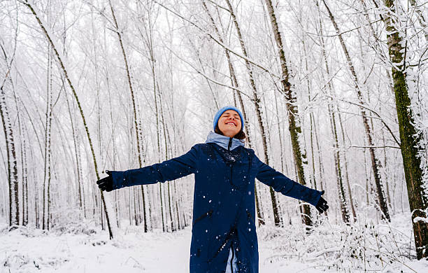 istock Joyful young woman embracing winter snowfall outdoors in nature. 2255030996