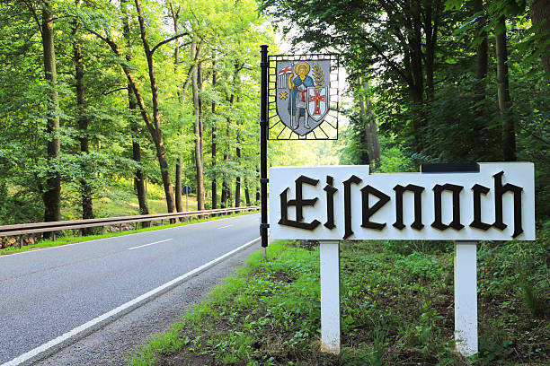 A close-up of a blue circular sign indicating a designated equestrian trail, mounted on a post with a forest background.
