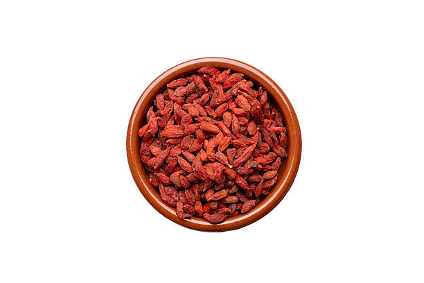 Bowl of dried goji berries on white background