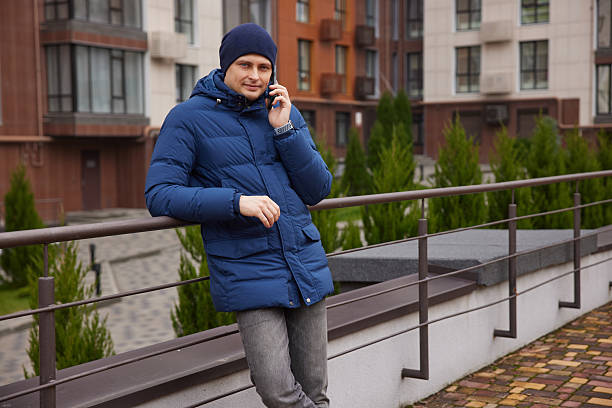 istock Young man talking on phone leaning on railing 2255034783