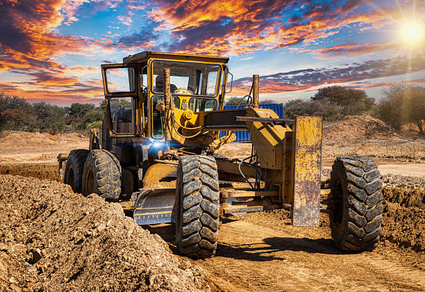 Rear quarter view of a grader on a new road and interchange construction site. Focused on grader.