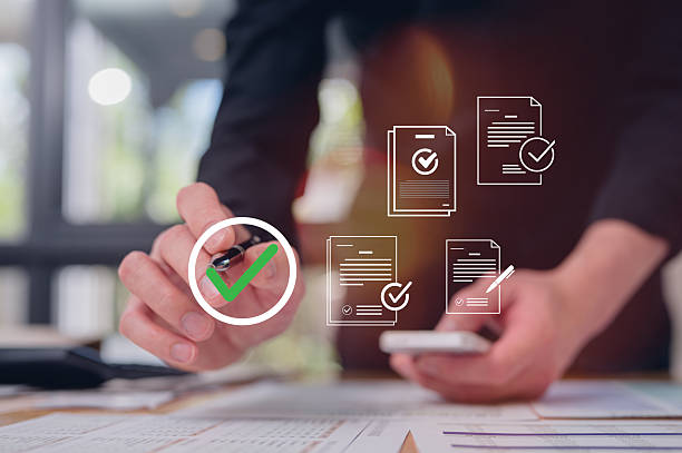 istock Businessman use pen review paper data charts and digital documents, utilizing intelligent management system to validate records and streamline final approvals workflow and quality assurance 2255036864