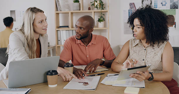 istock Collaboration, documents and laptop with team in design workplace for planning or project management. Computer, meeting and paperwork with designer people in coworking office for development 2255038842