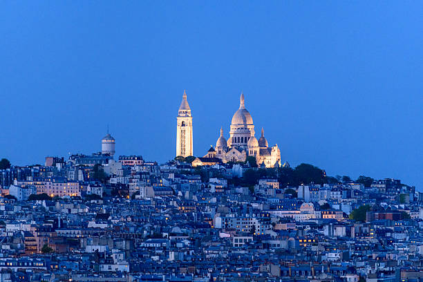 Sacre Coeur Basilica glowing above Montmartre rooftops