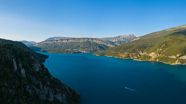 istock Wide alpine lake with forested ridges and clear sky 2255041019