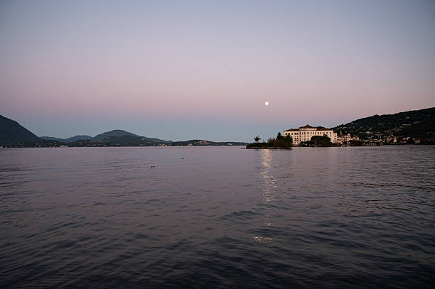 Borromeo Islands, Lake Maggiore, Northern Italian Lakes. Evening view of Isola Bella island with iconic Borromeo Palace facade, baroque architecture. Full moon.