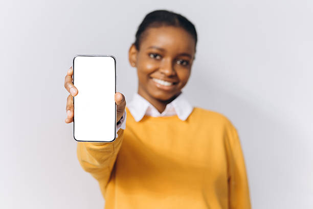 istock Young woman showing smartphone with empty display, promoting application or product. White background and copy space 2255044015