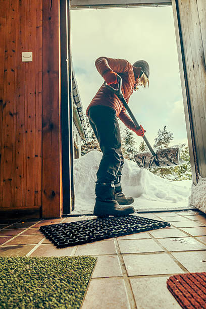 istock Senior woman clearing snow from her front door 2255045292