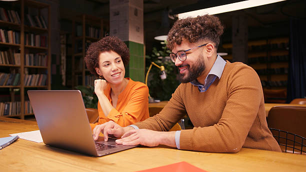 istock Businesswoman and businessman working together in modern office, analyzing documents, using laptop 2255047376