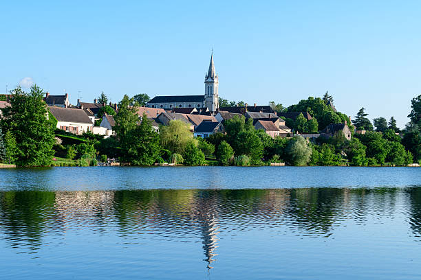 istock Historic church and village reflected on blue pond 2255048368