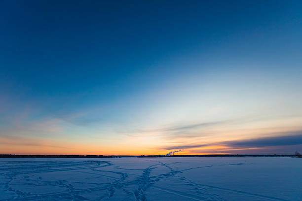 Sunset over winter field. Footprints in snow