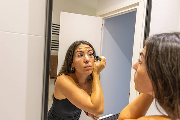 istock Woman applying mascara during her beauty routine in a modern bathroom 2255051231