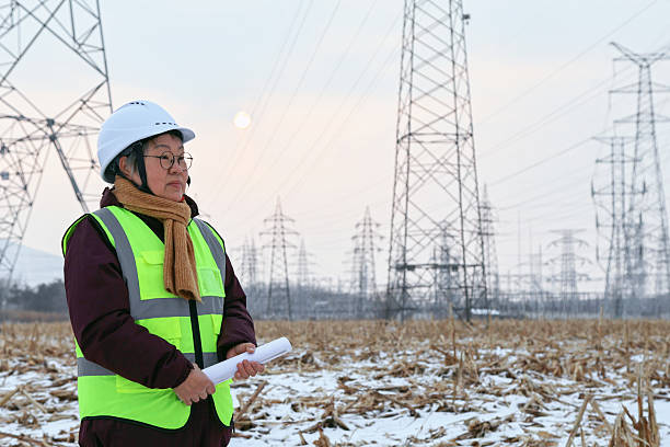 istock An older female engineer works outdoors, holding blueprints in her hand. 2255052296