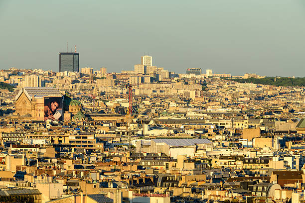 Rooftops, buildings and chimney pots in front of Montmartre and main façade of Basilica Sacré-Cur.